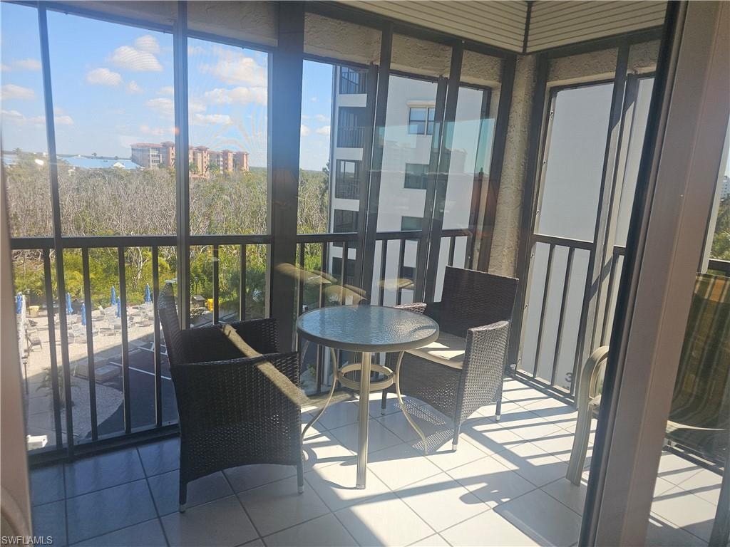 4th floor corner screened lanai with storm shutters overlooking community pool, sun patio, preserve and bay