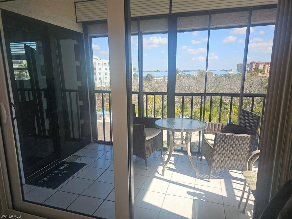 Corner screened lanai with tile flooring and healthy amount of natural light accessible from both living area and primary bedroom via newly installed impact sliders