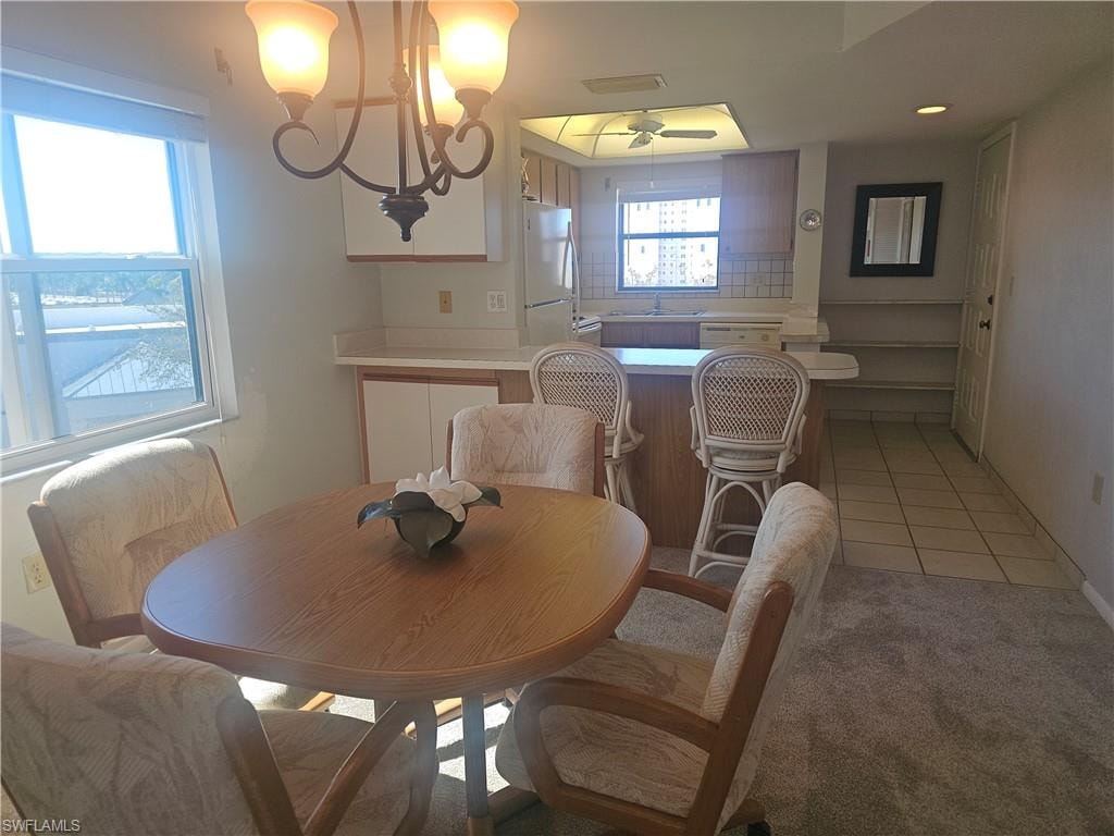 Dining space featuring light colored carpet and light tile patterned flooring