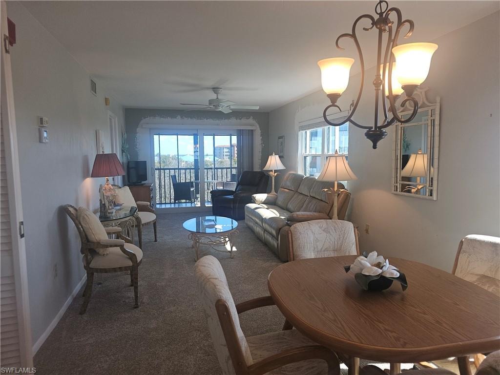 Carpeted dining room featuring ceiling fan and hanging lights