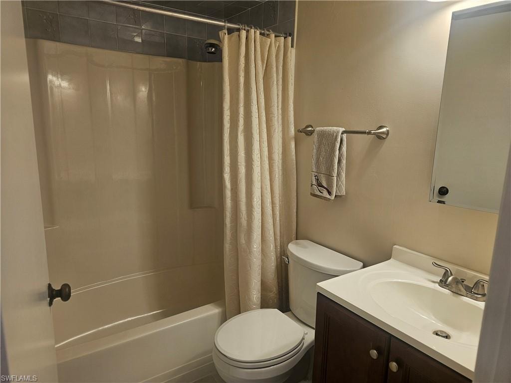 Full bath with shower / tub combo with curtain and vanity