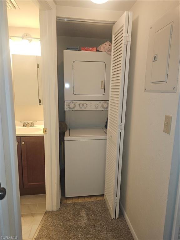 Laundry area featuring stacked washer / dryer, electric panel, carpet floors, and tile patterned flooring