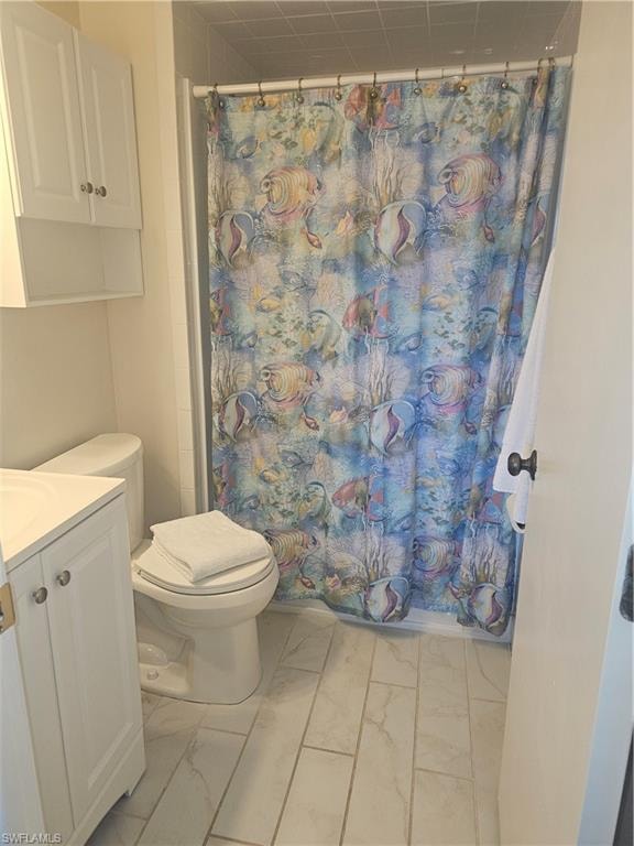 Full bath with vanity and light marble finish flooring