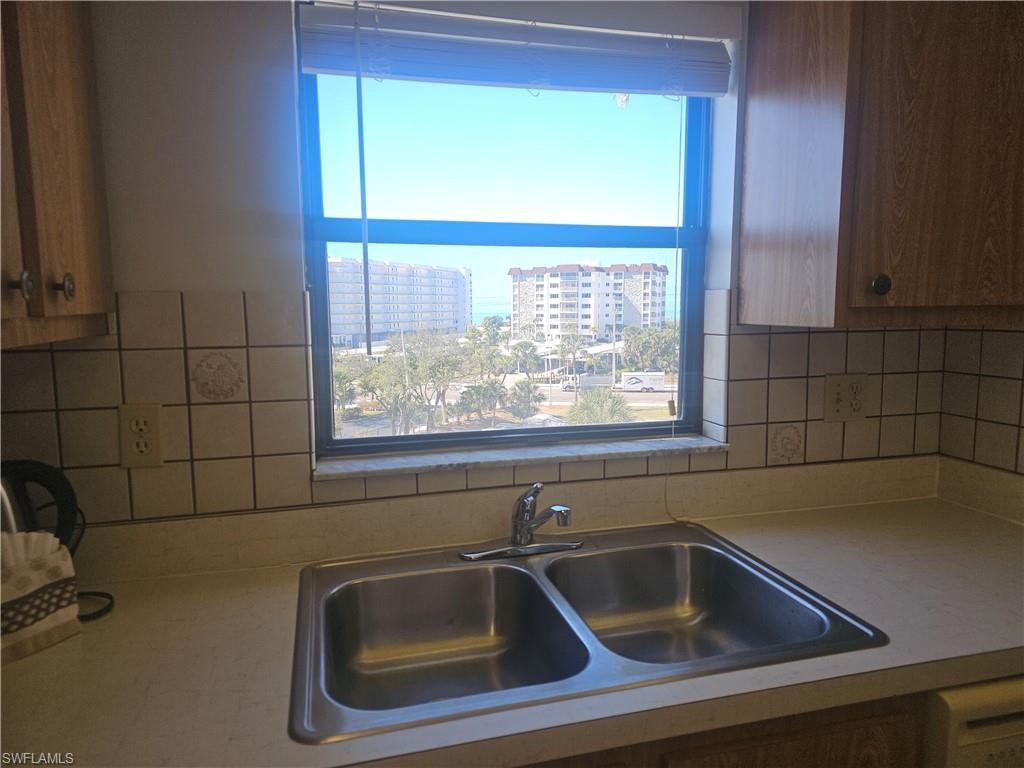 Kitchen featuring tasteful backsplash, light countertops, wood finish cabinets, and a city view