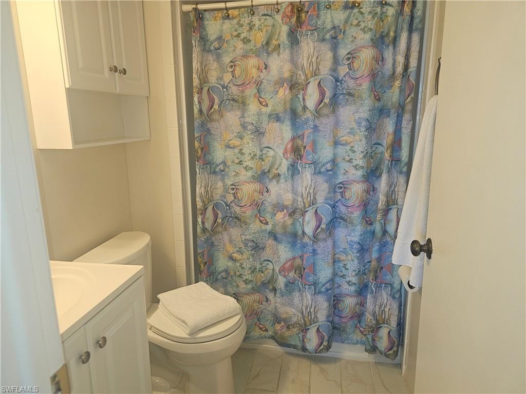 Full bath featuring curtained shower and vanity