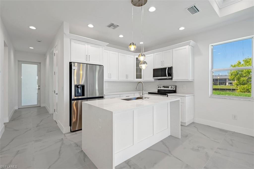 Kitchen with marble finish floor, a sink, stainless steel appliances, and recessed lighting