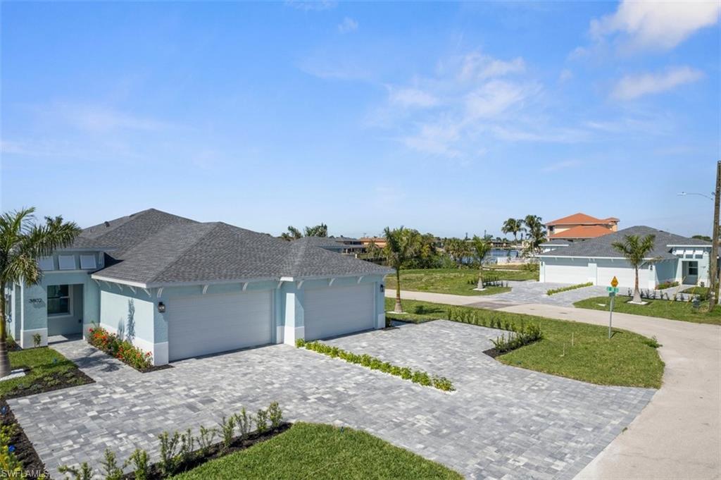 Single story home with a shingled roof, decorative driveway, an attached garage, and stucco siding