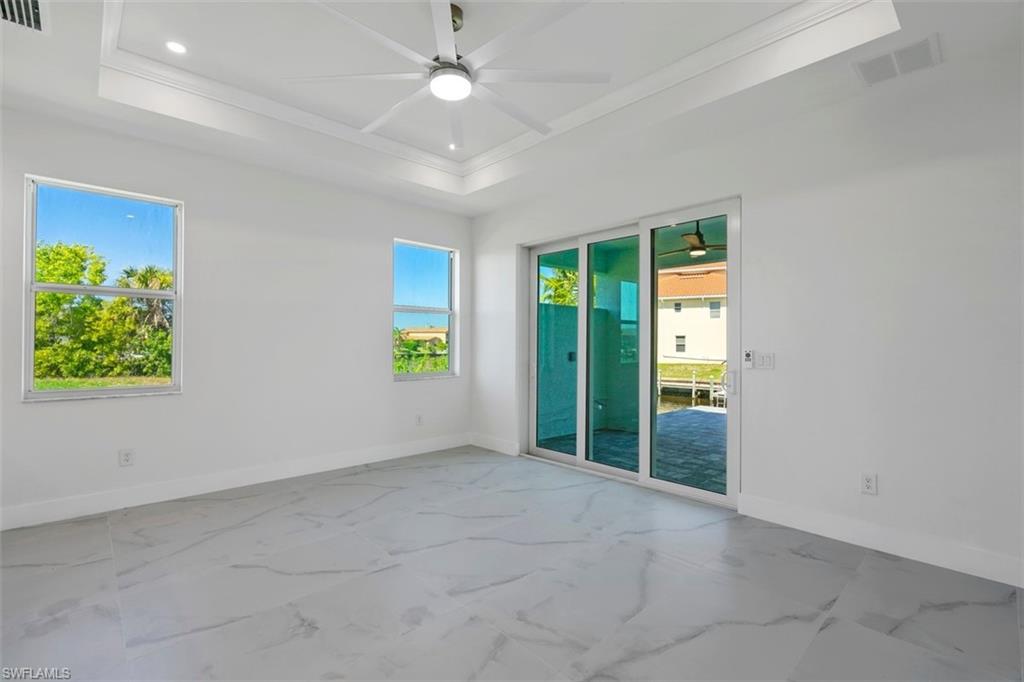 Unfurnished room with marble finish floor, baseboards, visible vents, and ceiling fan