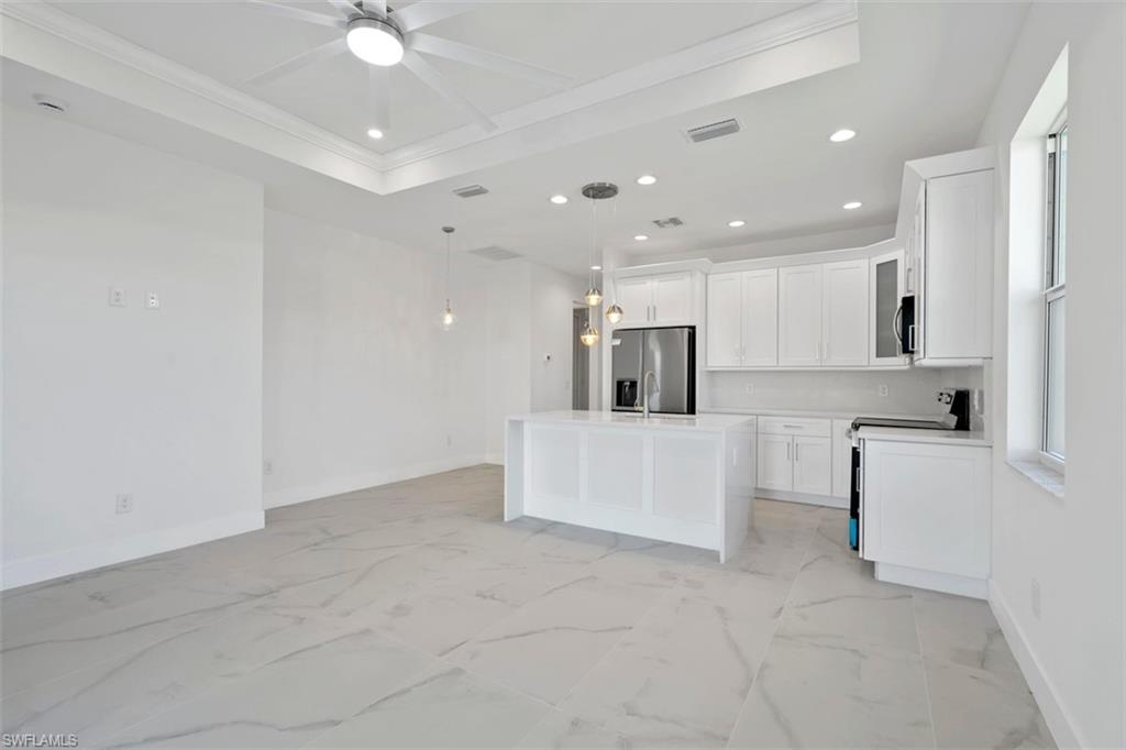Kitchen with baseboards, marble finish floor, ceiling fan, recessed lighting, and appliances with stainless steel finishes
