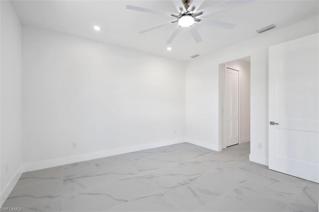 Unfurnished room featuring marble finish floor, baseboards, and visible vents