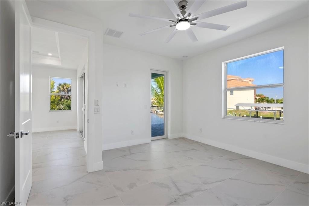 Spare room with baseboards, marble finish floor, visible vents, and a ceiling fan