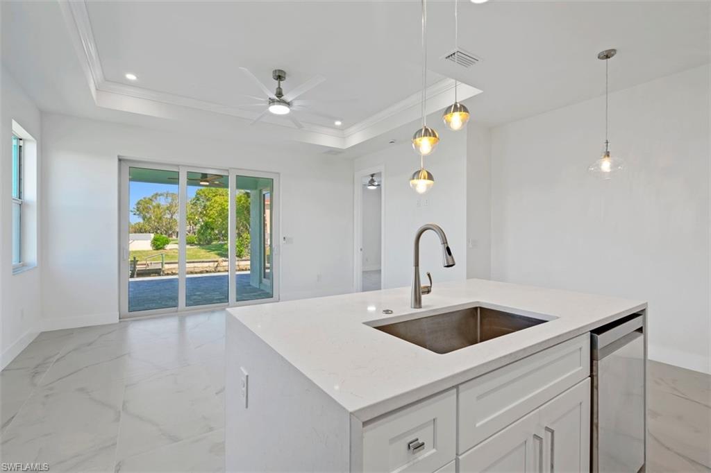 Kitchen featuring dishwasher, visible vents, a sink, and a raised ceiling