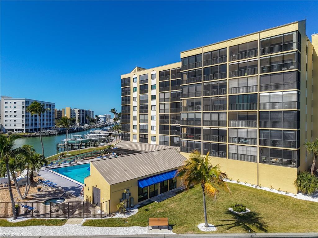 View of apartment building / complex featuring a community pool and a water view