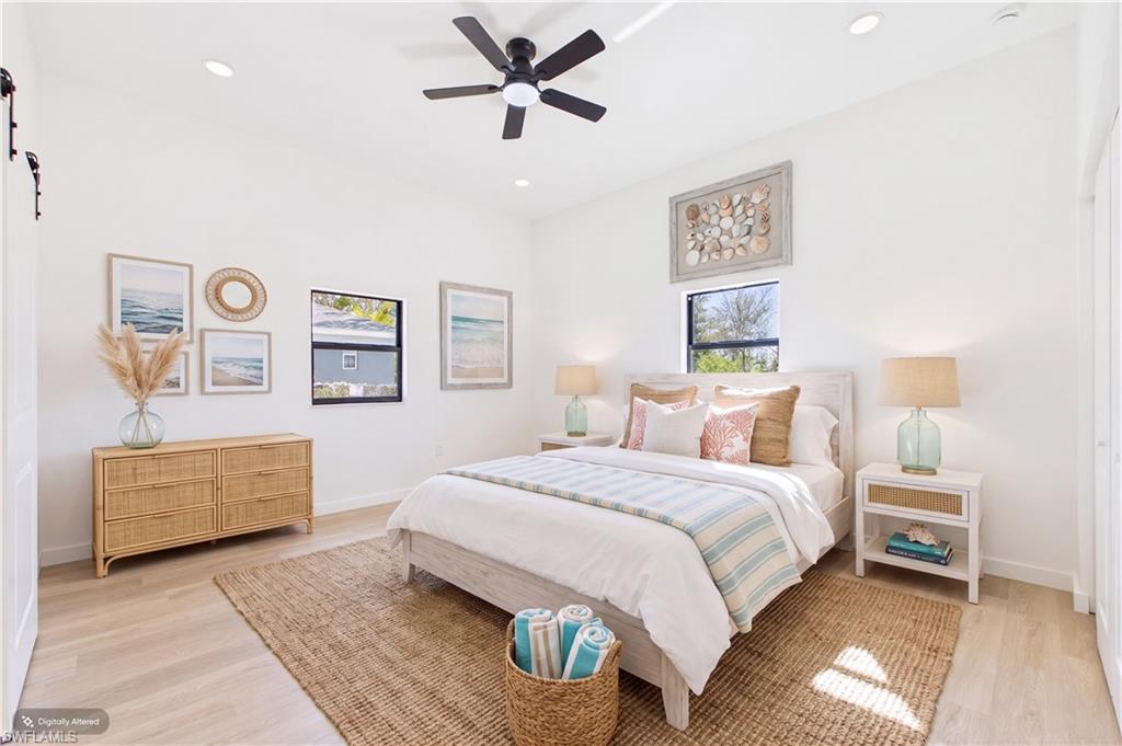 Bright room featuring light wood-finish flooring, white walls, recessed lighting, and a ceiling fan