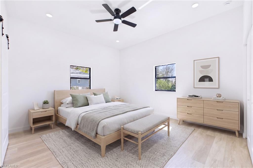 Spacious room with light wood-finish flooring and bright white walls
