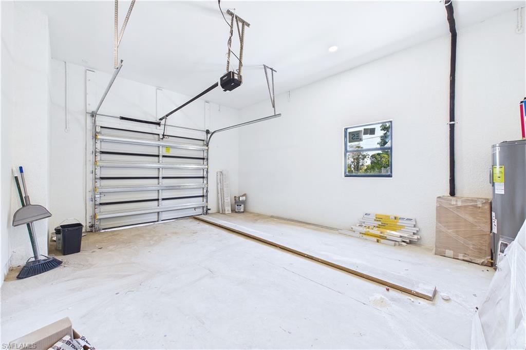 Garage featuring water heater and a garage door opener