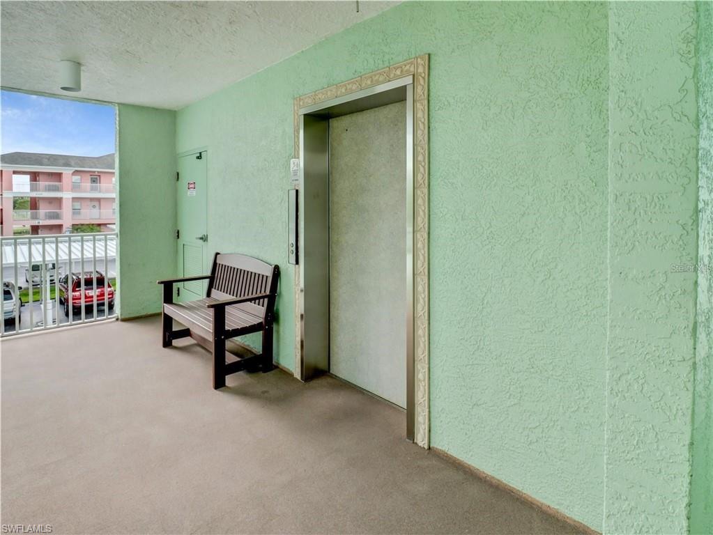 Sitting room with a textured wall, elevator, and a textured ceiling