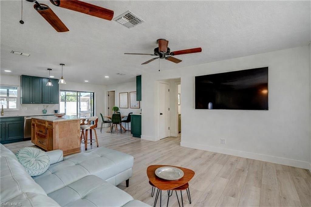 Living area featuring light wood-style floors, a ceiling fan, and a textured ceiling