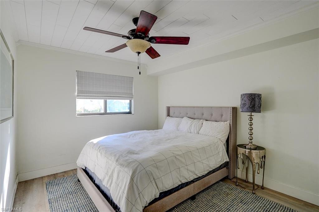 Bedroom featuring ceiling fan, crown molding, wood-type flooring, and wooden ceiling