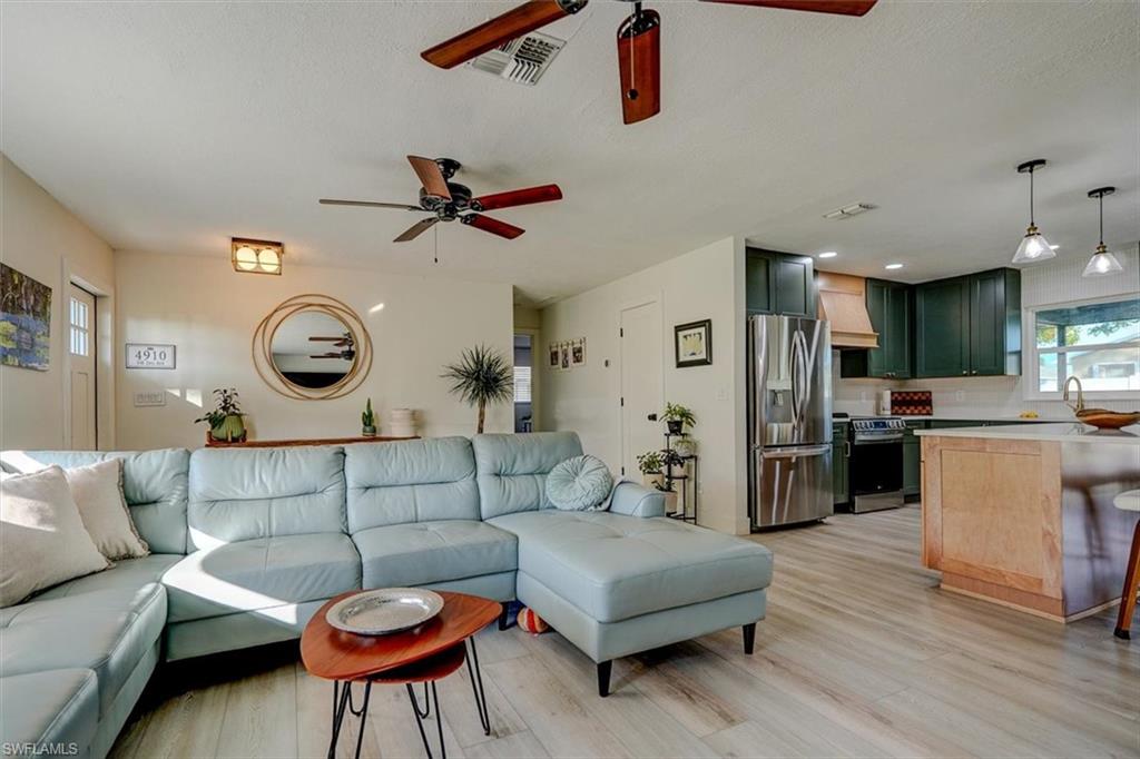 Living room featuring ceiling fan, light hardwood / wood-style floors, and sink