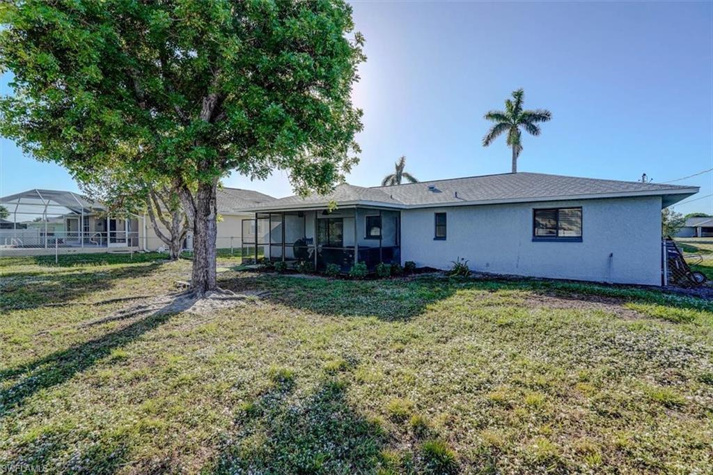 Back of property featuring a sunroom and a yard