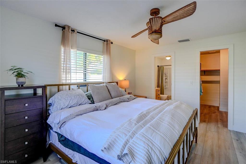 Bedroom featuring a walk in closet, ceiling fan, connected bathroom, light hardwood / wood-style floors, and a closet