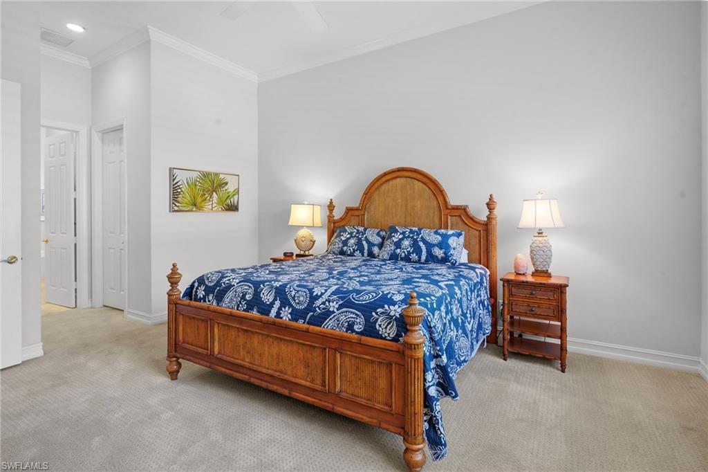 Carpeted bedroom featuring crown molding and ceiling fan