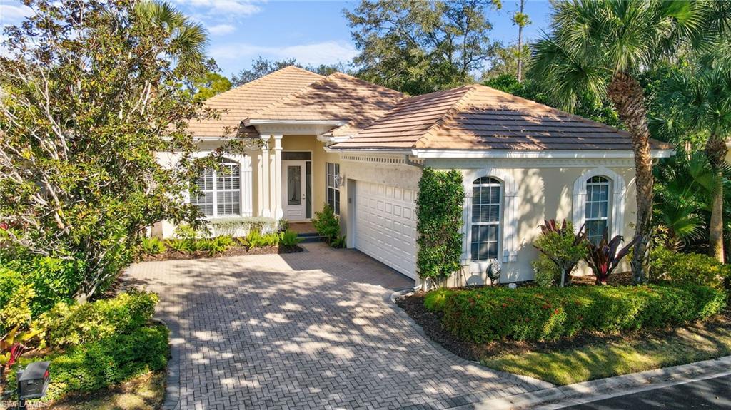 View of front of house with stucco siding, decorative driveway, a garage, and a tiled roof