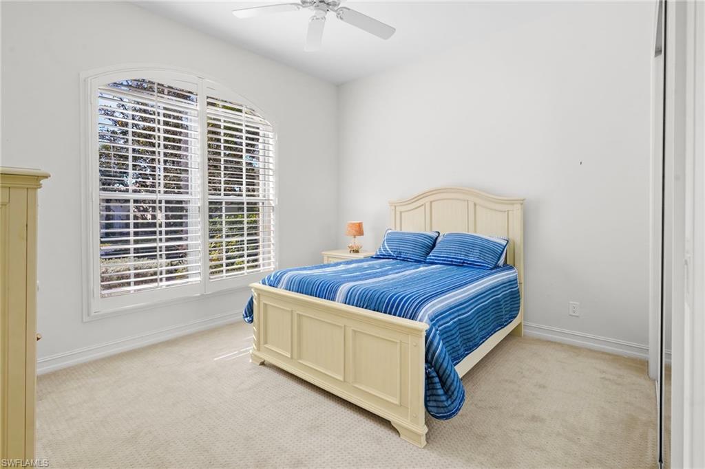 Bedroom with light colored carpet and a ceiling fan