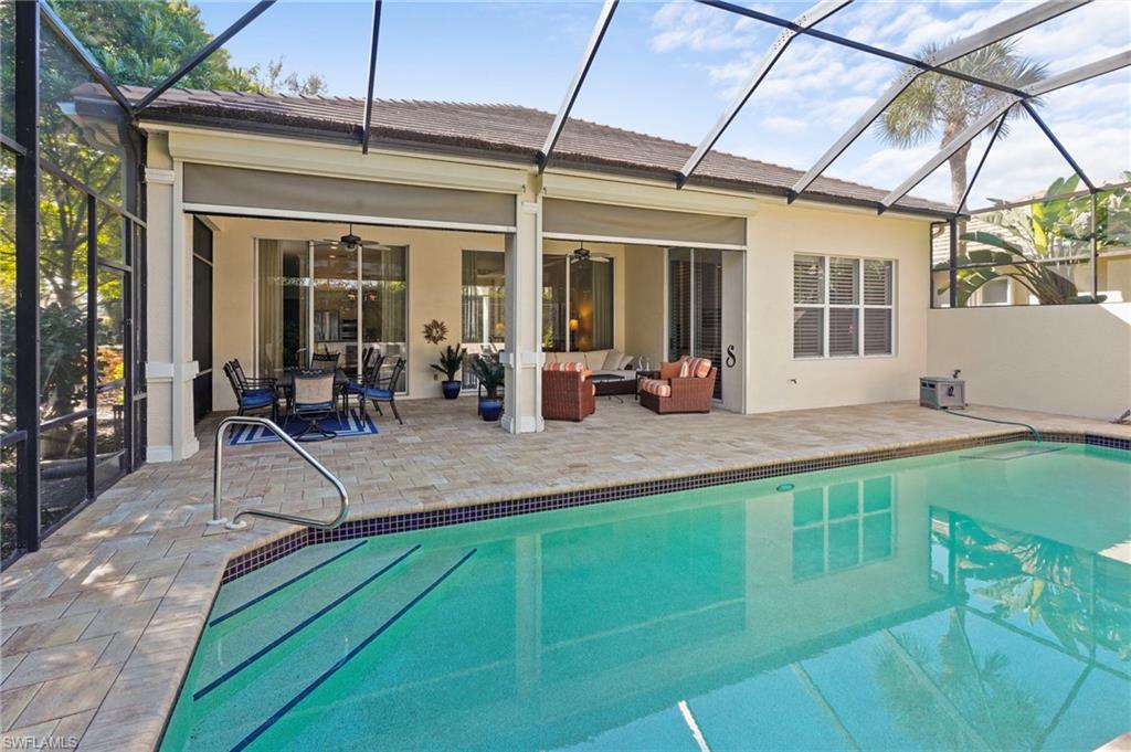 Rear view of property with a sunroom, a lanai, and a patio area