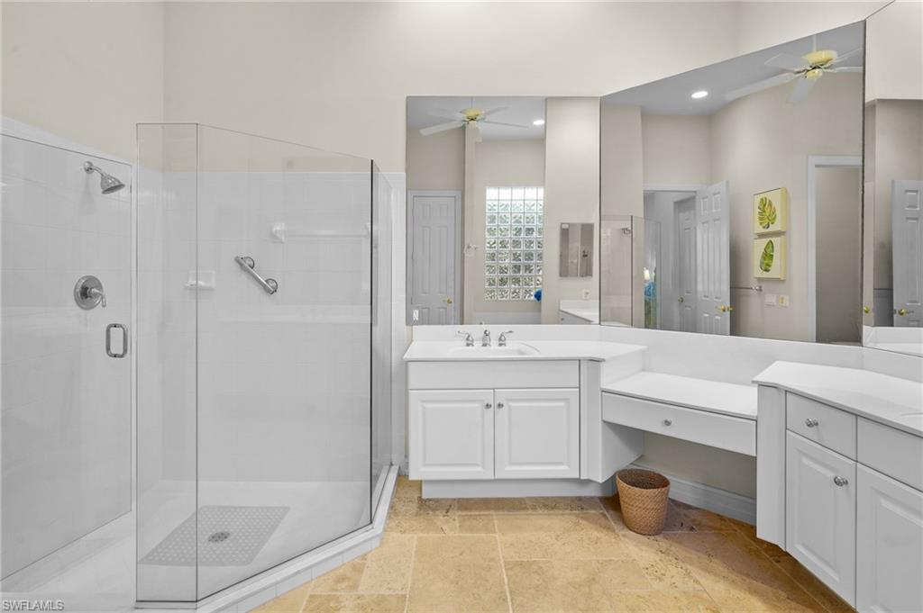 Full bath with ceiling fan, a shower stall, and vanity