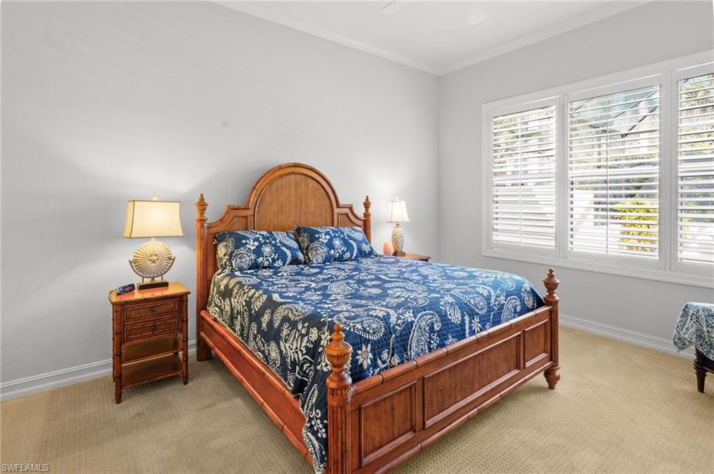 Carpeted bedroom with ornamental molding and ceiling fan