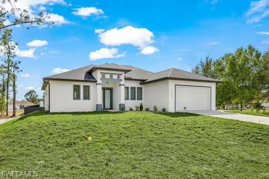 Prairie-style home featuring a front yard, stucco siding, concrete driveway, and an attached garage