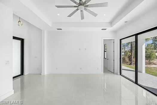 Unfurnished room with a tray ceiling and ceiling fan