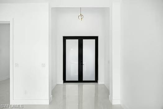 Foyer entrance featuring french doors and concrete floors