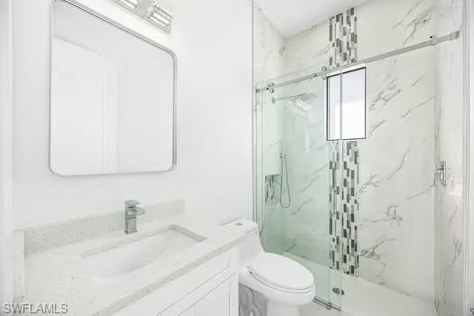 Bathroom featuring vanity and a marble finish shower