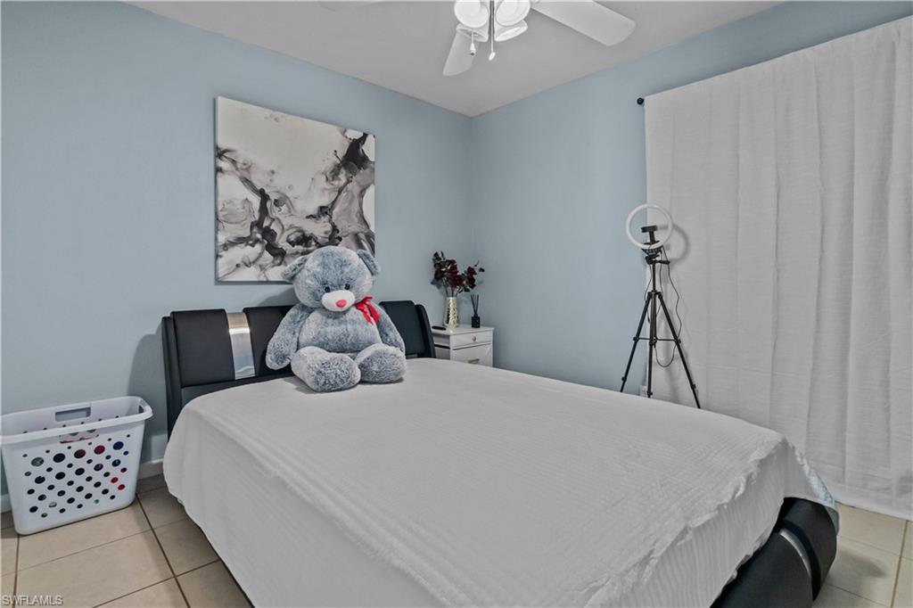 Bedroom featuring light tile patterned floors and a ceiling fan