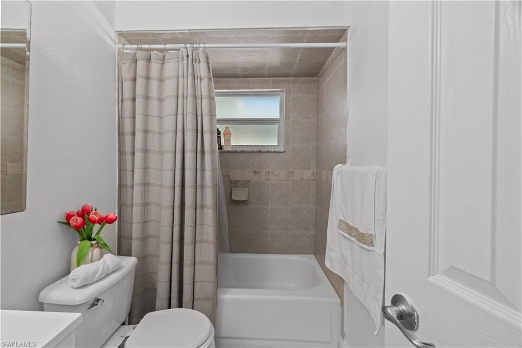 Full bathroom with shower / bath combo with shower curtain and vanity