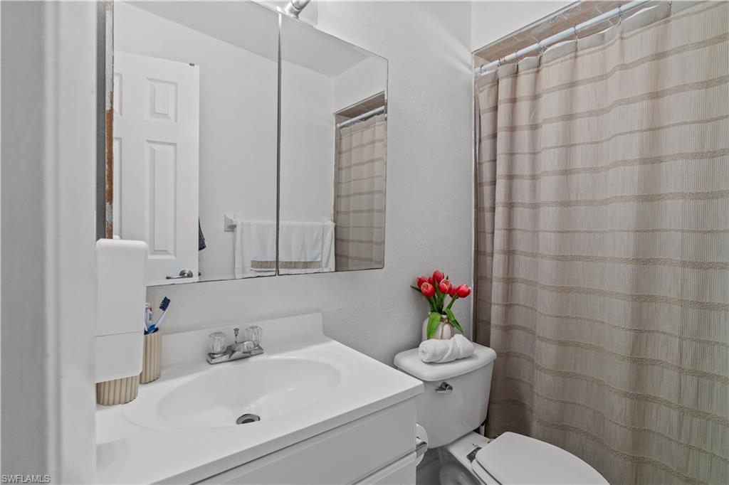 Full bath featuring a shower with shower curtain and vanity
