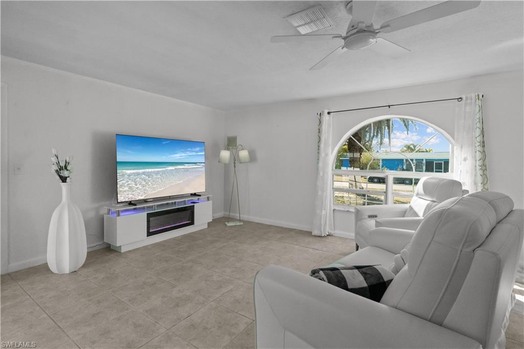 Living area with ceiling fan and light tile patterned floors