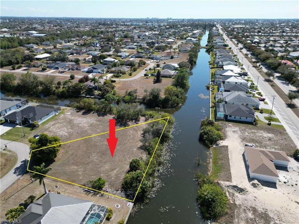 Aerial view of residential area with property parcel outlined and view of freshwater canal