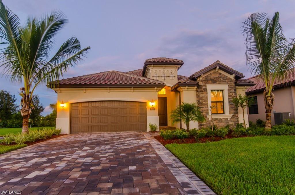 Mediterranean / spanish home featuring stucco siding, a tiled roof, decorative driveway, and an attached garage