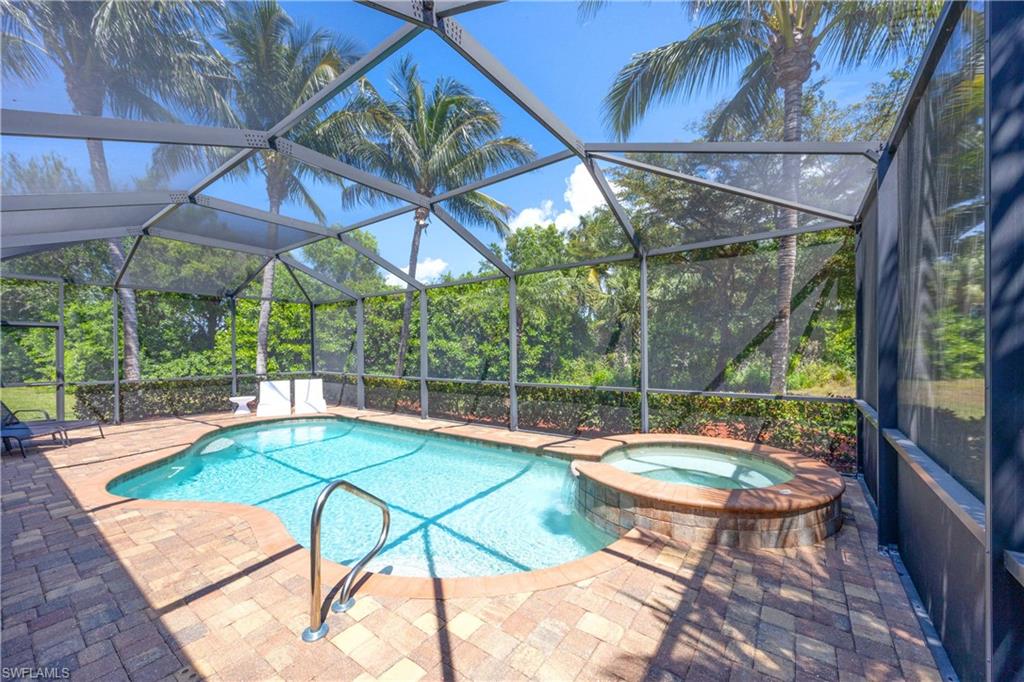 View of swimming pool with a pool with connected hot tub, a lanai, and a patio area