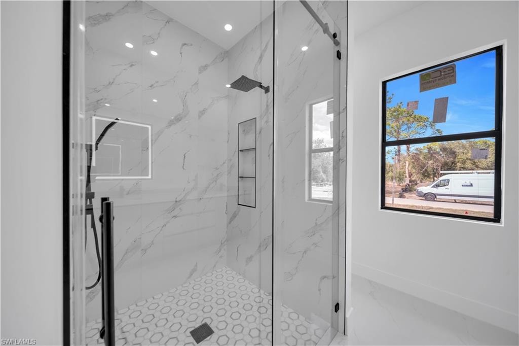 Bathroom with a tile finish shower and baseboards