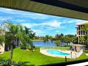 Swimming pool with a lawn and a water view