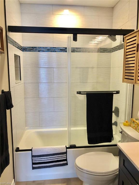 Bathroom featuring vanity and enclosed tub / shower combo