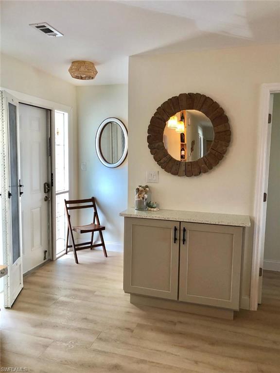 Entryway with light wood-style flooring and baseboards