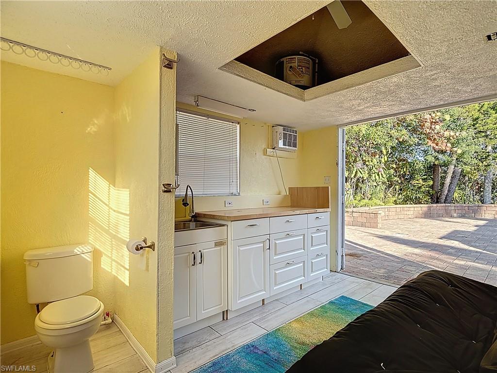Bathroom featuring vanity, a textured ceiling, a textured wall, ceiling fan, and wood tiled floors