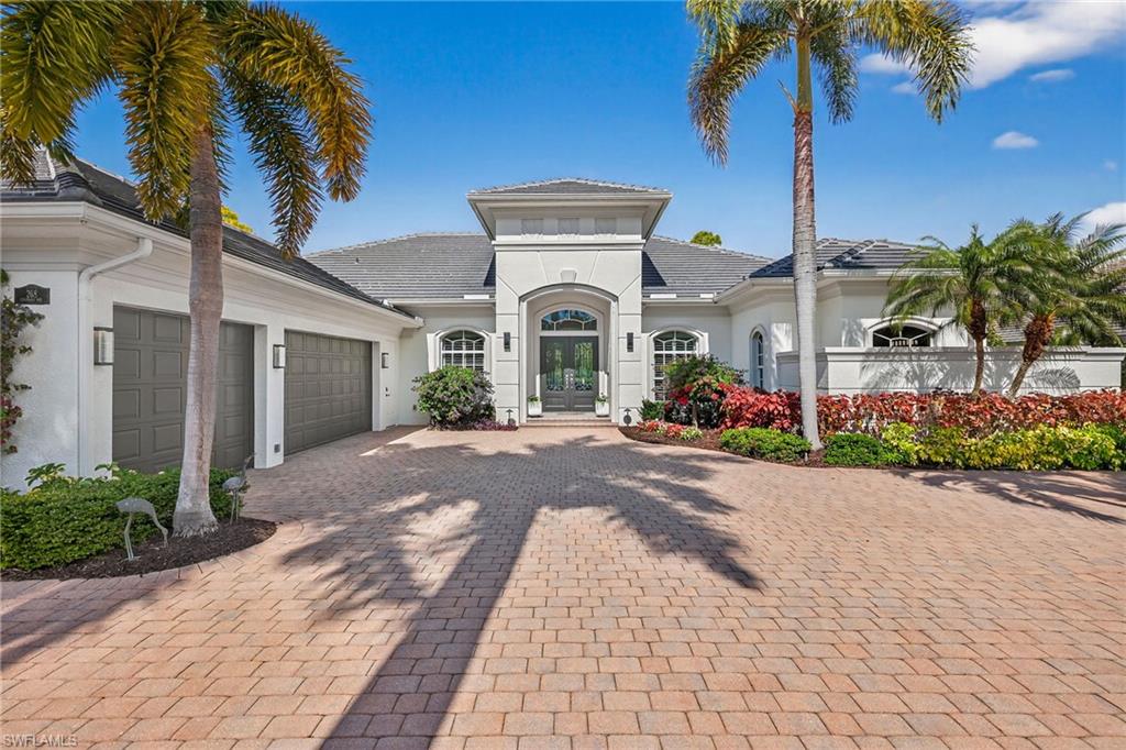 View of front of home with decorative driveway, stucco siding, an attached garage, and french doors