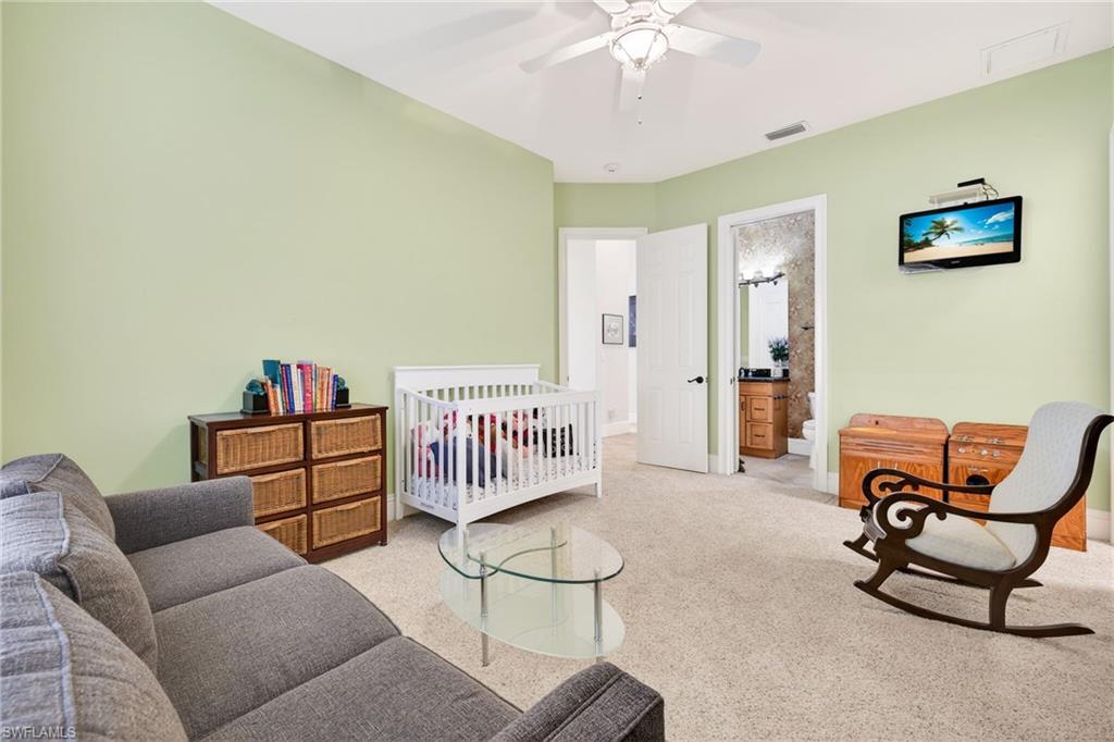 Bedroom featuring carpet, a ceiling fan, and ensuite bath